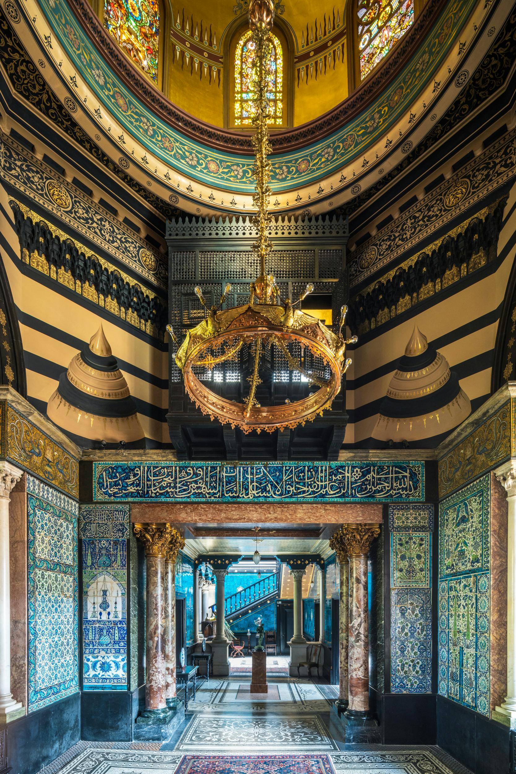 Christmas party venue in Leighton House with ornate chandeliers and vibrant tiles.