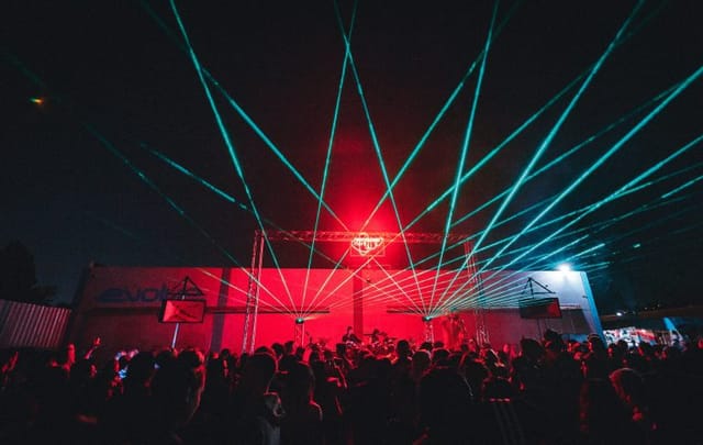 Vibrant lounge area with dynamic laser lights at Evolve Project LA event.