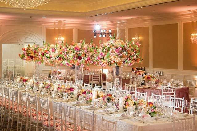 Elegant wedding venue with floral centerpieces and chiavari chairs in upscale banquet hall.