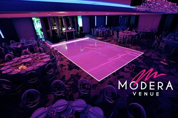 Elegant Modera Ballroom with round tables, perfect for weddings and corporate events.