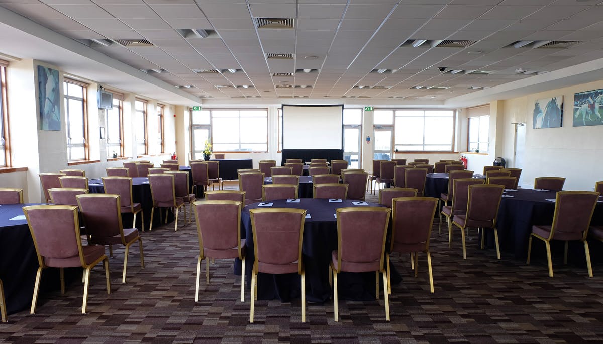 Desert Orchid Suite conference room with dark tables, ideal for events and networking.