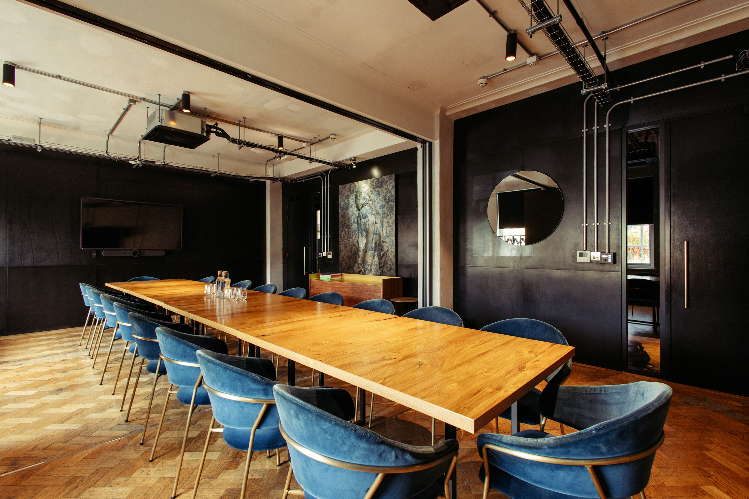 Modern meeting room with wooden table and blue chairs, perfect for corporate workshops. - Banner