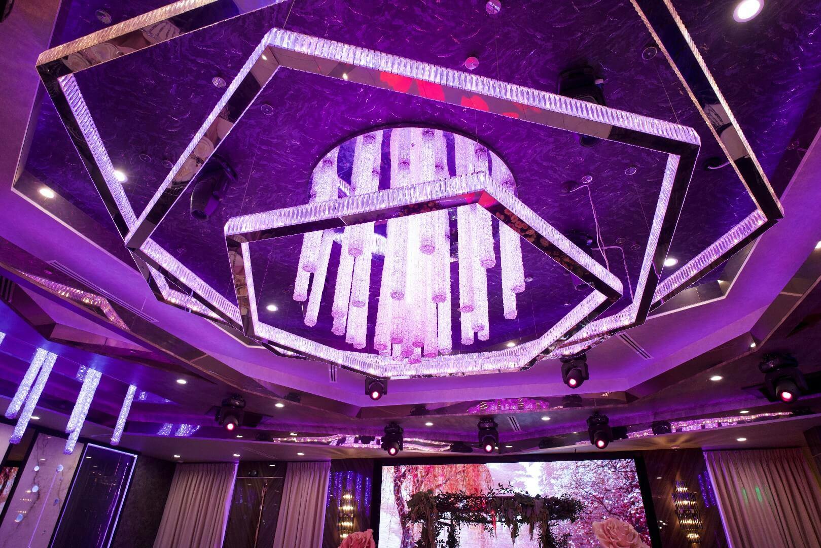 Corporate event at Bellaj Banquet Hall with elegant chandelier and vibrant lighting.