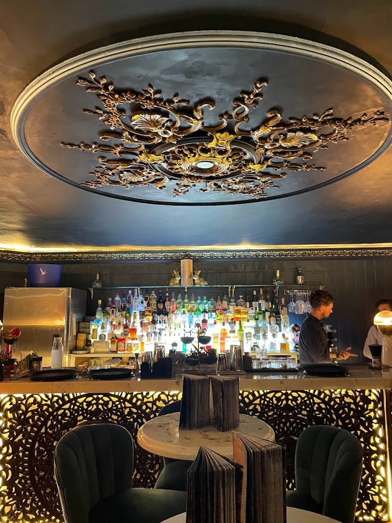 Stylish bar at The Rabbit's Hole with ornate ceiling, ideal for cocktail receptions.
