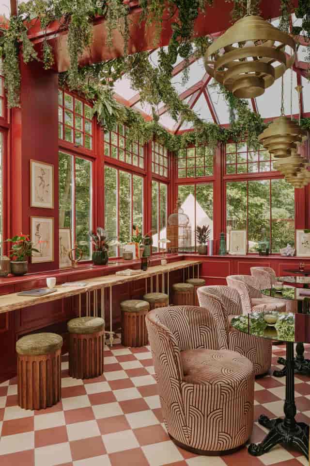 Elegant event space in EVE Kensington with large windows and rich red walls.