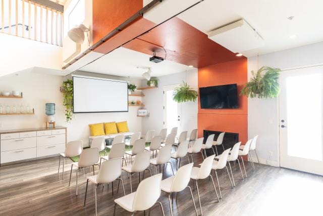 Modern meeting room with white chairs and orange accents, perfect for workshops and team meetings.