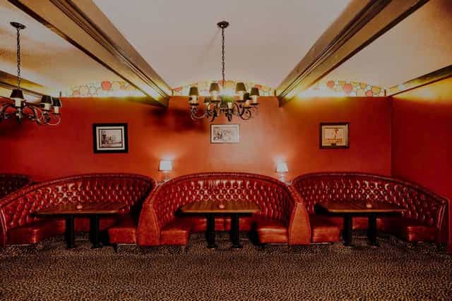 Cozy meeting space with plush red booths at Long Beach Petroleum Club for networking events.