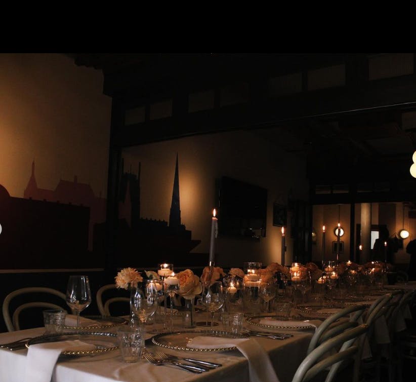 Elegant dining table with candlelight in sophisticated venue for corporate events.