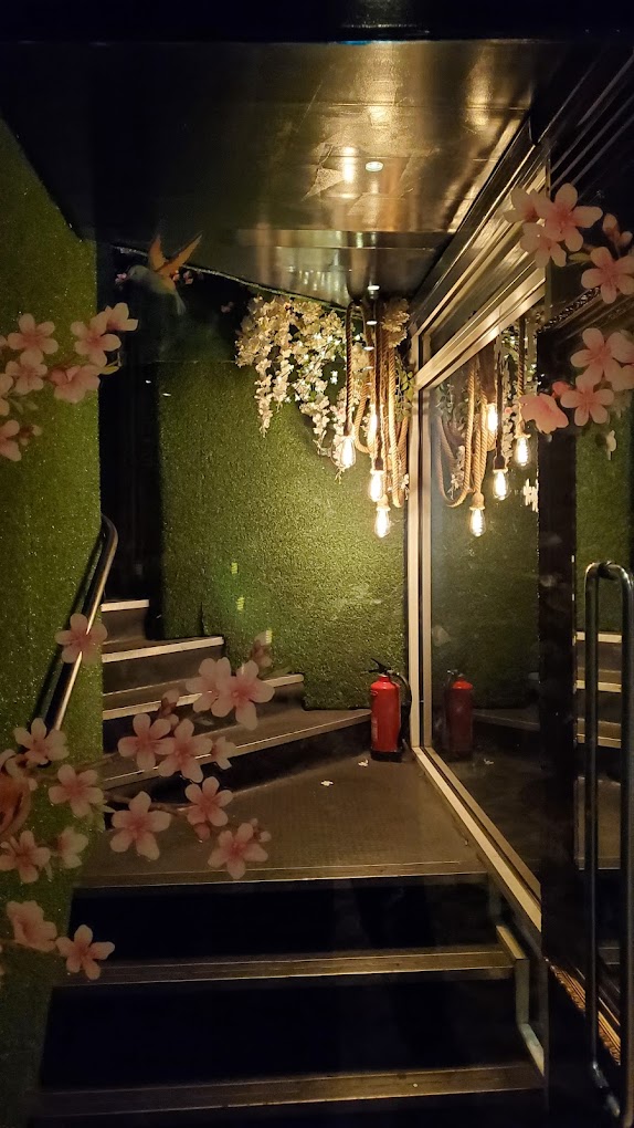 Stylish venue entrance with lush green walls for upscale events at The Rabbit's Hole. - Banner