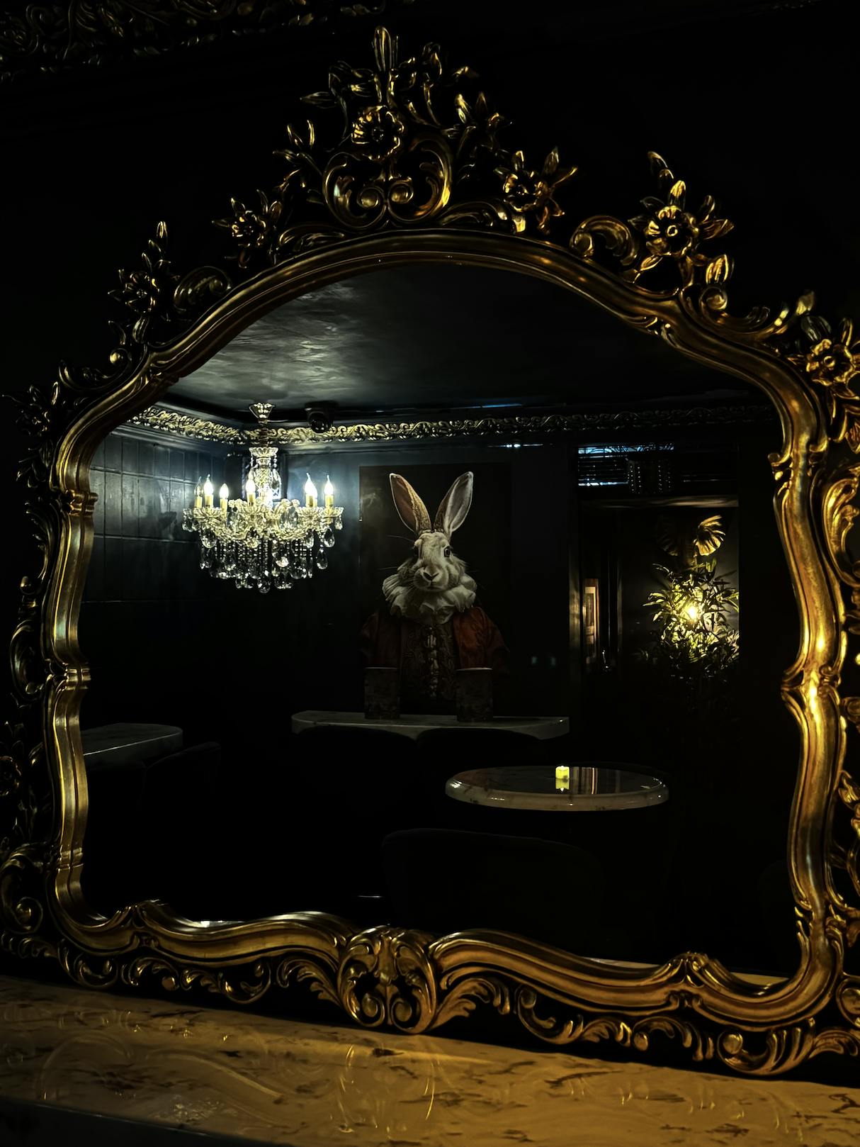 Whimsical event space with ornate mirror and chandelier at The Rabbit's Hole.