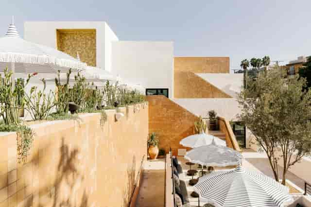 Modern outdoor pool deck with terracotta walls, ideal for networking events and gatherings.