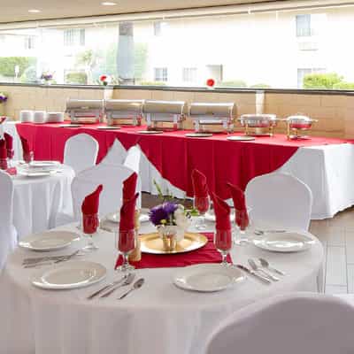 Elegant event space at Olive's Bistro with red and white decor for memorable dining experiences.