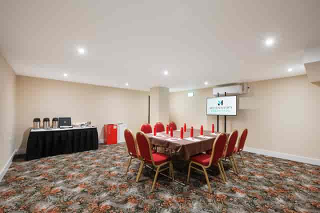 Windsor Suite meeting room with round table, red chairs for corporate events in London.