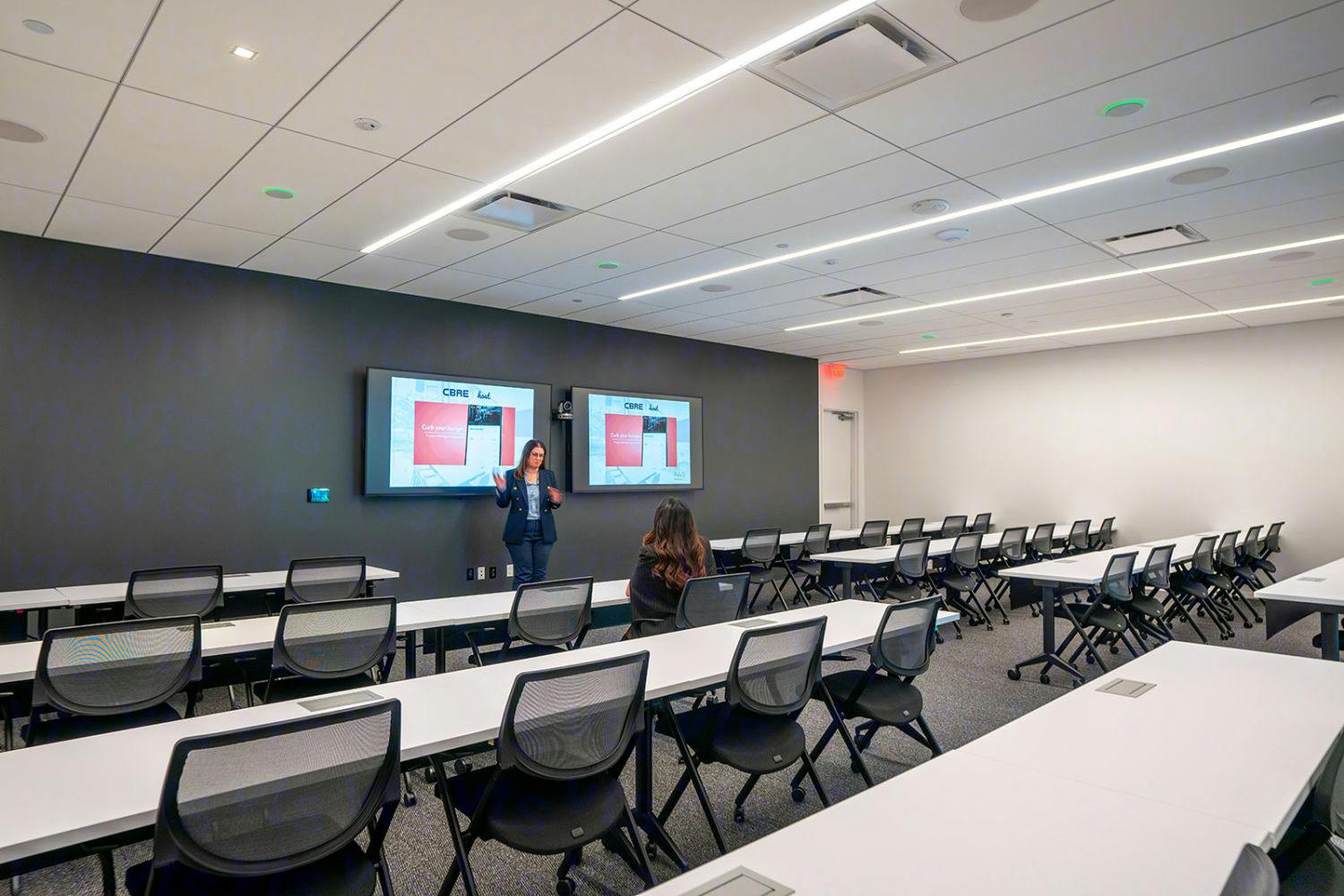 Modern classroom training room with large screens, ideal for workshops and presentations.