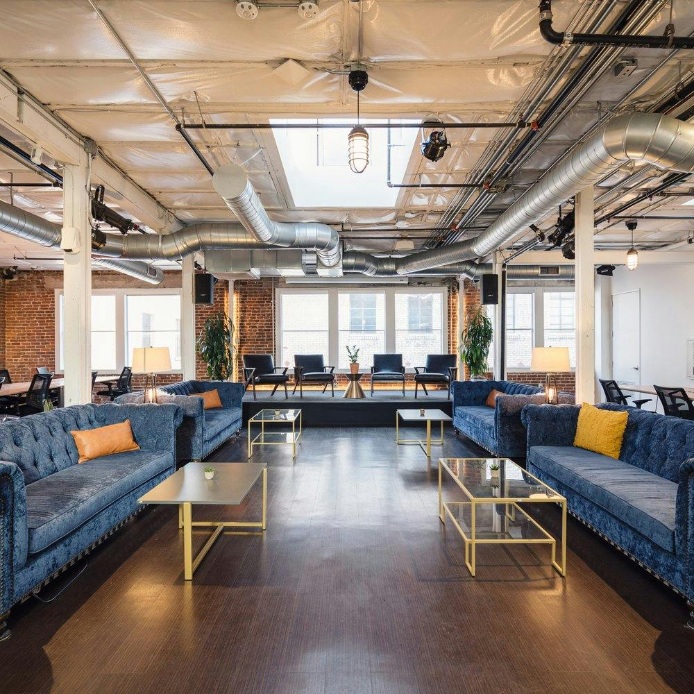 Modern event space with blue sofas, ideal for networking and casual meetings.