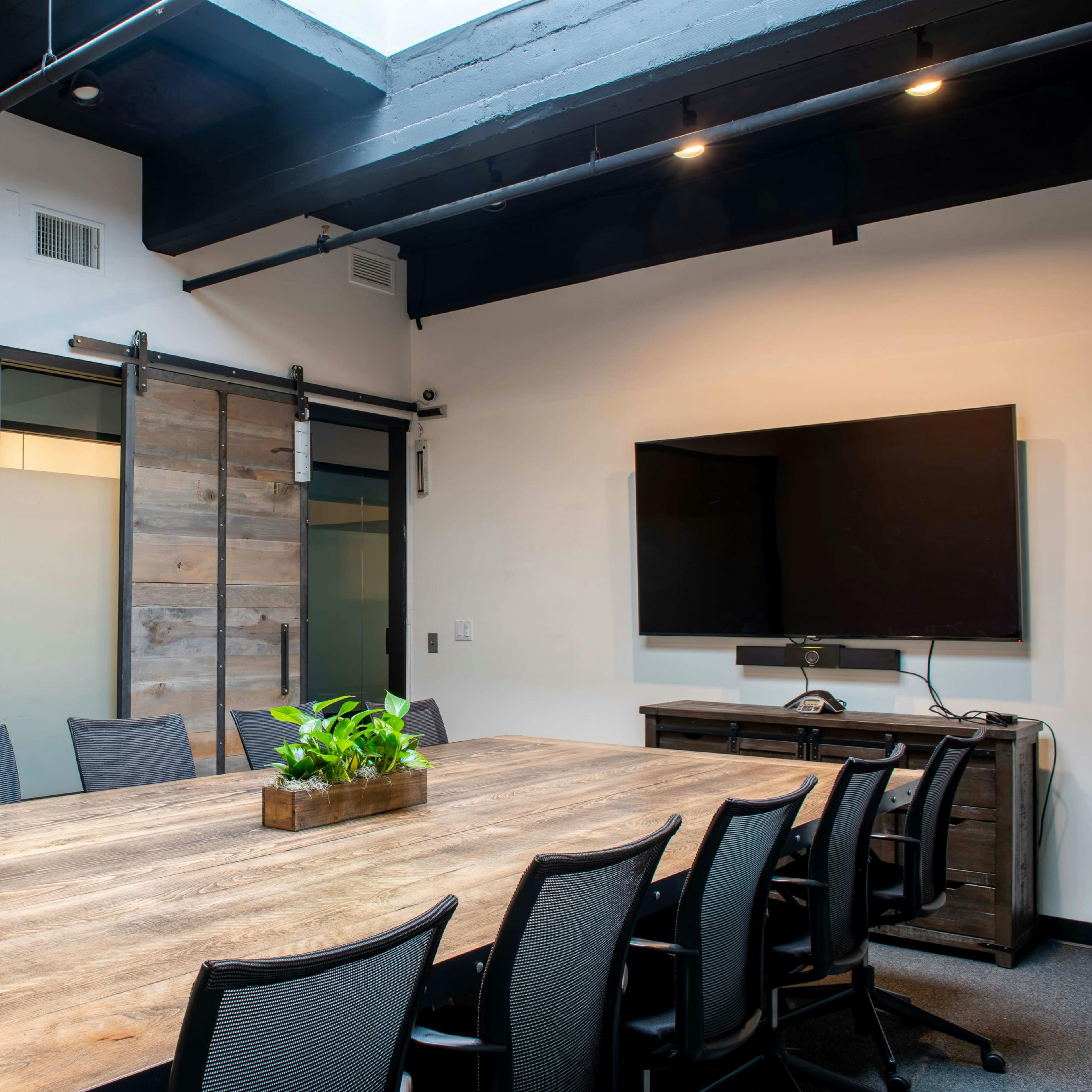 Modern rentable meeting room with large wooden table for collaborative events.