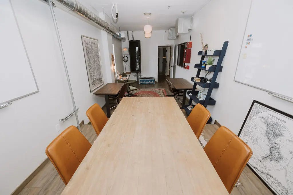 Modern conference room with wooden table and leather chairs, perfect for workshops.