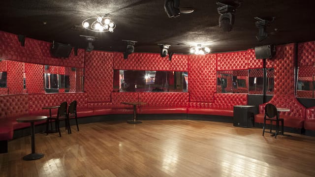 Stylish event space with red tufted walls, perfect for private parties and gatherings.
