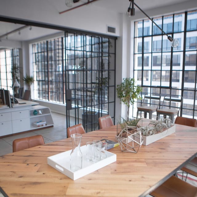 Modern coworking space with large windows, ideal for workshops and team meetings.
