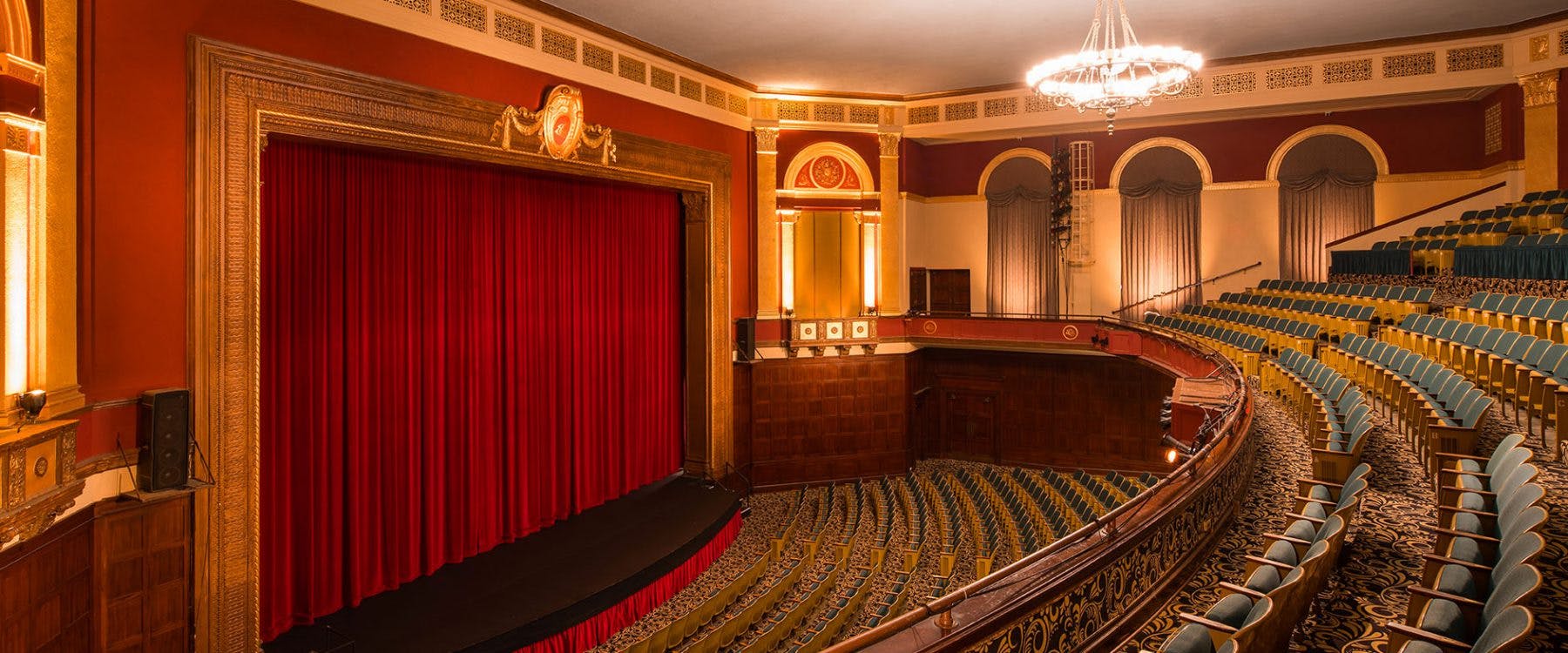 Broadway-style theater with red curtain, ideal for performances and gala events.