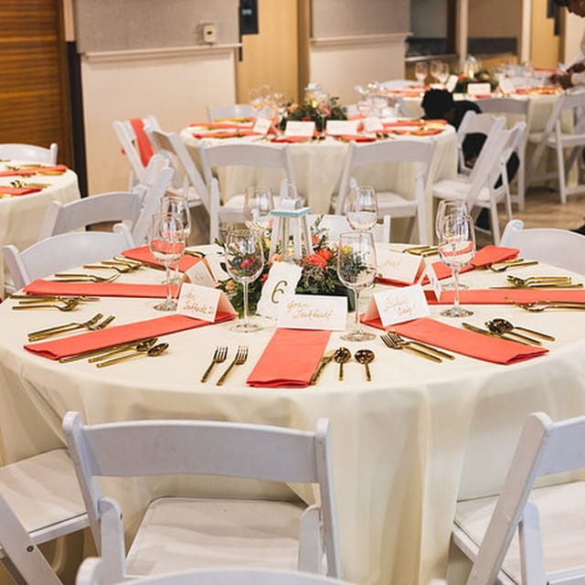 Elegant banquet table with coral napkins at CMG Cultural Center for weddings and events.