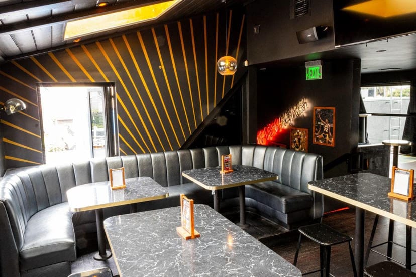 Dance floor at The Naughty Pig, sleek black and gold design for private events.