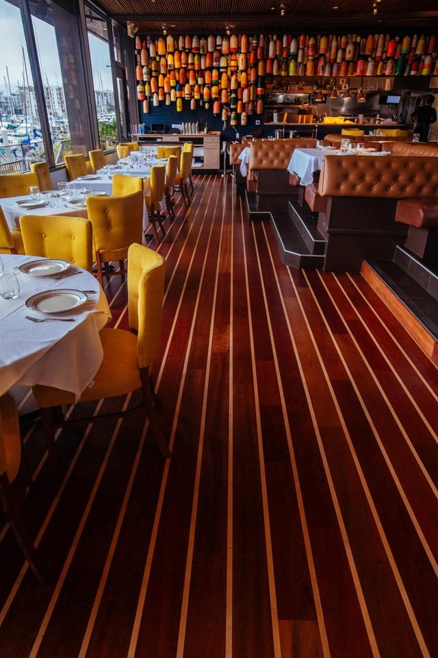 Stylish dining area with yellow chairs and wooden floor, ideal for upscale events.