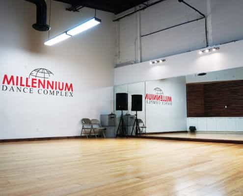 Versatile dance studio with wooden floor and mirrors for events and workshops.