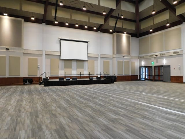 Main Hall at Liberty Station: spacious venue with elevated stage for conferences and weddings.