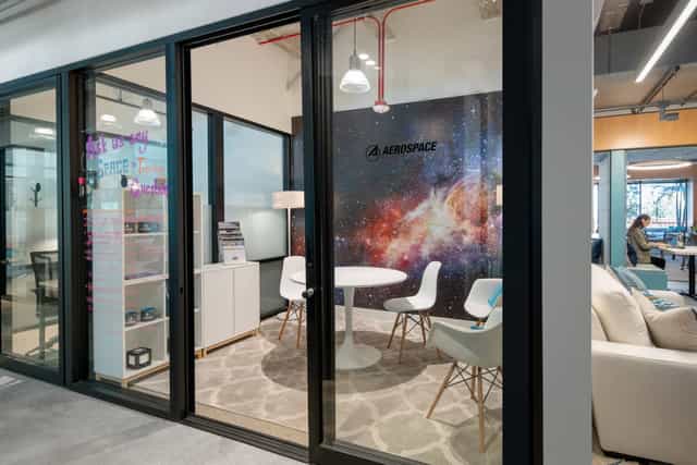 Modern meeting space with round table, galaxy backdrop for team brainstorming sessions.