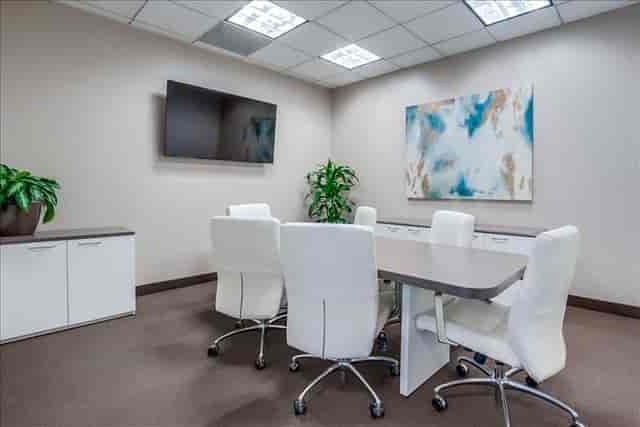Modern meeting room with sleek table, ergonomic chairs for corporate events.