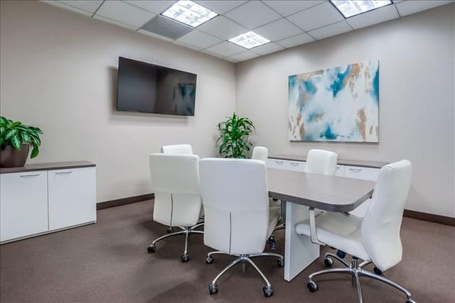 Modern meeting room with sleek table, ergonomic chairs for corporate events.