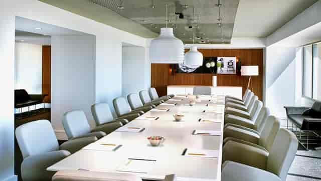 Modern conference room with sleek table, ideal for corporate meetings and workshops.