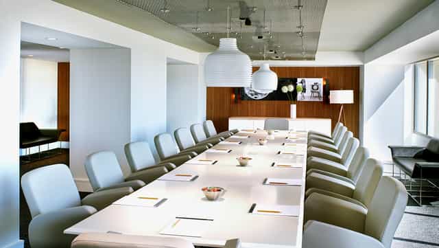 Modern conference room with sleek table, ideal for corporate meetings and workshops.
