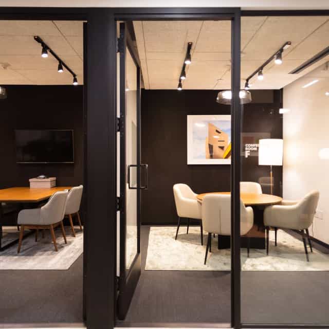 Modern meeting room with glass walls, ideal for collaboration and brainstorming sessions.
