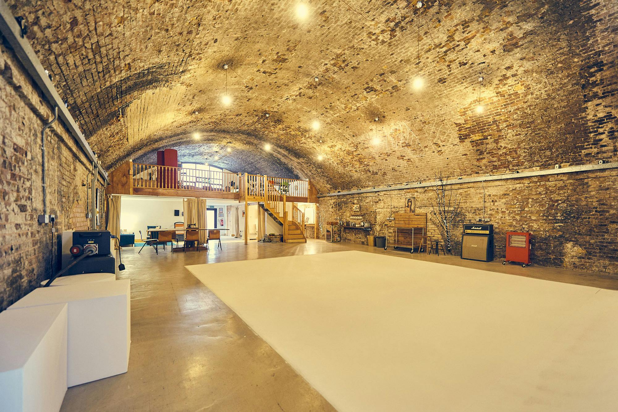 Spacious event venue with arched ceiling, ideal for corporate meetings and creative events.