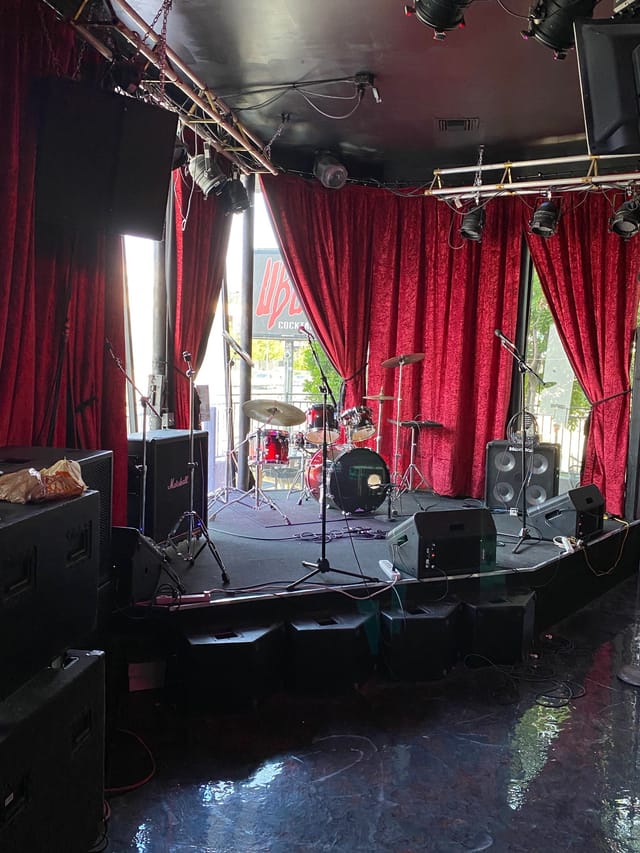 Bar Area at Universal Bar & Grill with stage setup for live performances and concerts.