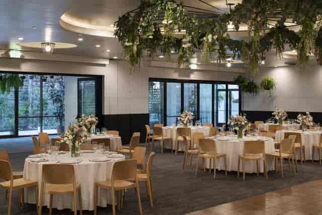 Elegant event space with round tables and floral centerpieces, perfect for weddings or corporate events.
