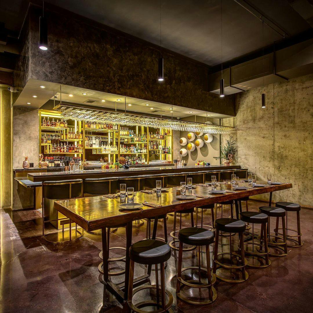 Modern restaurant bar with warm lighting, ideal for corporate events and intimate gatherings.
