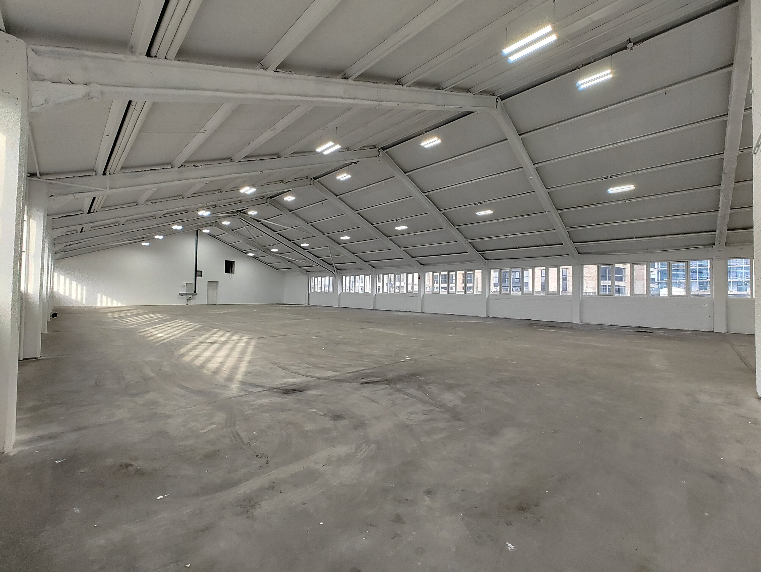 Spacious White City Warehouse venue with high ceilings for conferences and exhibitions. - Banner