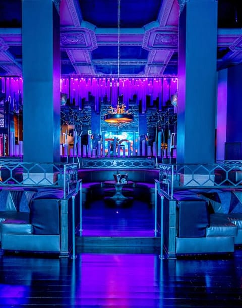 VIP tables in Parq Nightclub with vibrant purple lighting for upscale events and celebrations.