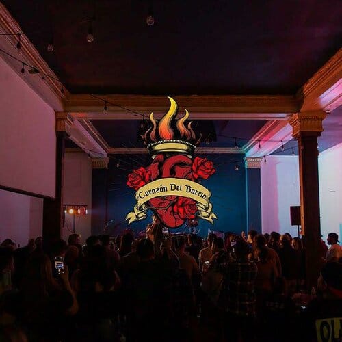 Vibrant event space at Corazon del Barrio with rose and flame logo, ideal for gatherings.