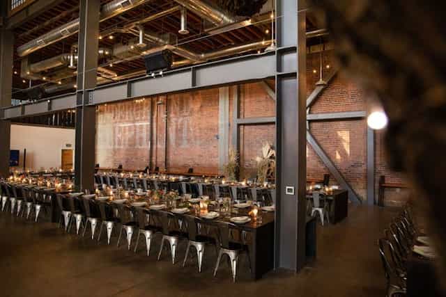 Spacious event venue with elegant dining table, ideal for corporate dinners and celebrations.