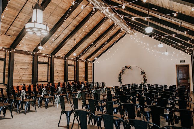 Fully furnished event space with rustic beams, ideal for weddings and corporate meetings.