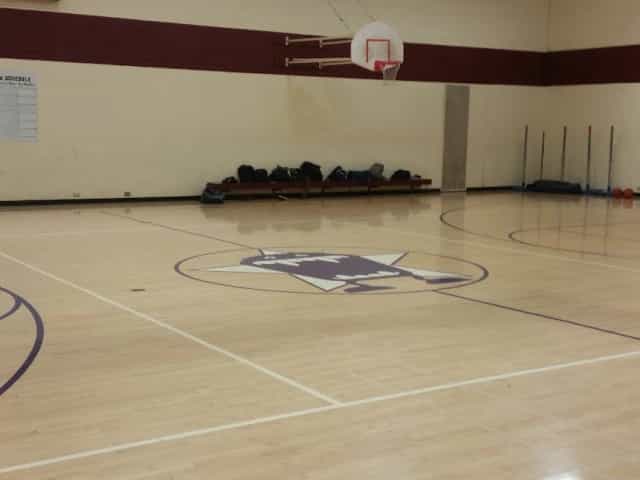 Gymnasium floor with central logo at Linda Vista Recreation Center for sports events.