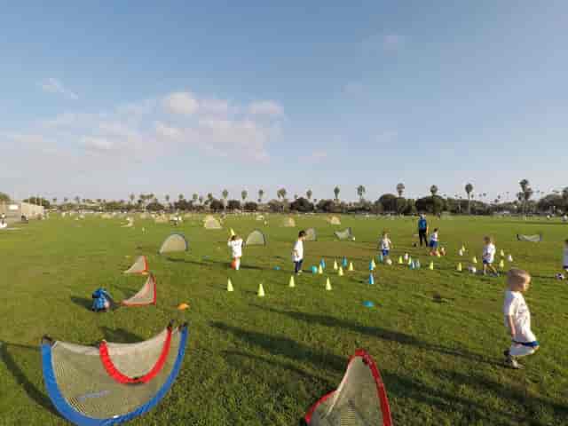 Children playing sports on a vibrant multipurpose field for team-building events.