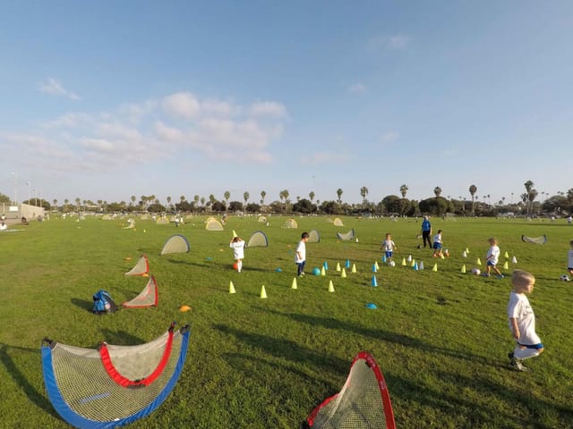Children playing sports on a vibrant multipurpose field for team-building events.