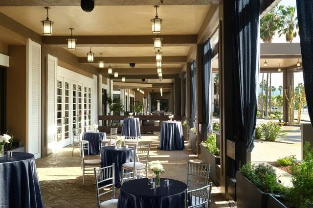 Seascape Ballroom outdoor event space with navy tables and floral centerpieces.