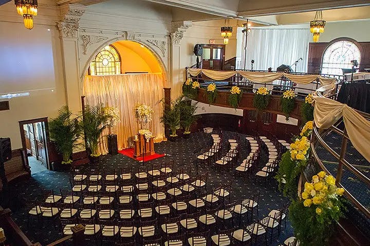 Elegant wedding balcony with floral decor and tiered seating at The Abbey on Fifth Avenue.