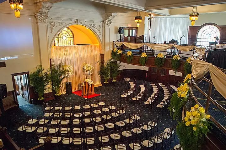 Elegant wedding balcony with floral decor and tiered seating at The Abbey on Fifth Avenue.